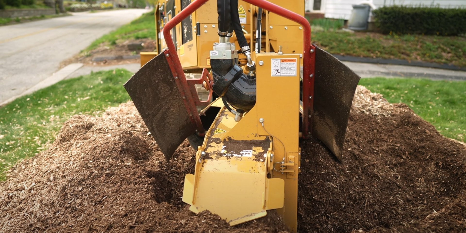 Complete stump grinding service for clean landscape restoration Yellow stump grinder machine removing tree stump from residential lawn